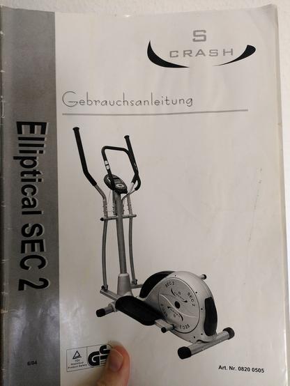 Bild des Deckblattes einer Bedienungsanleitung für den im Beitrag erwähnten Crosstrainer. Das Deckblatt ist in Graustufen gedruckt. Am linken Rand ist die Typenbezeichnung auf grauem Balken und in der Mitte der Crosstrainer selbst. Oben dominiert das Markenlogo.