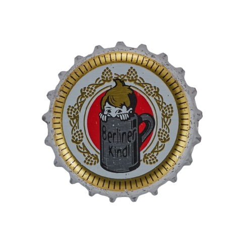 Head and hands of a kid peeking out from within a beer mug. The mug has written the name of the beer on it — Berliner Kindl. The background is made up by a red dot behind the beer mug and three ornamental golden concentric circles, being the second one the most detailed one picturing what looks like hops.