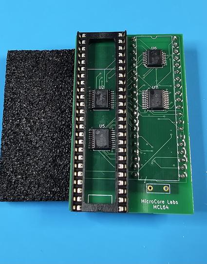 A bare green adapter board pcb with small logic chips.