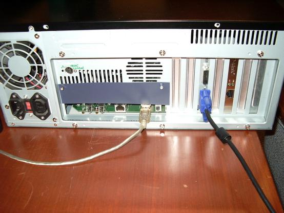 The read connectors of a "Sawtooth" PowerMac G4 logic board mounted inside a 4U rackmount ATX case.