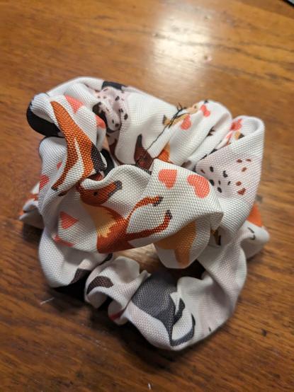 two white hair scrunchies with a horse pattern
