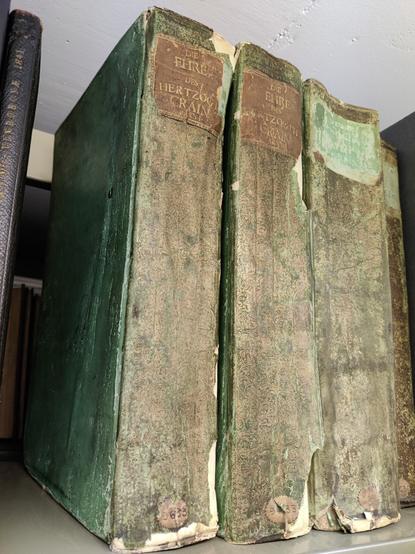 Imposing looking books with green painted sides and gold and green brocade paper spines.