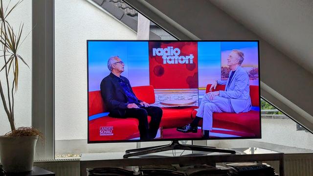 Foto eines Fernsehers. Man sieht einen Ausschnitt aus dem SWR Programm. Der Moderator ist in Gespräch mit den Autor des ARD Radio Tatort, Friedrich Ani.