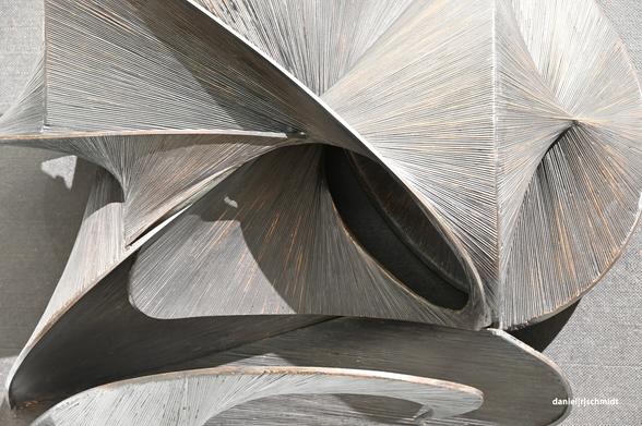 Die Aufnahme zommt in ein Kunstrelief ein. Man sieht geflochtene Stränge, die wie einzelnen Blüten von der Wand herabstehen.