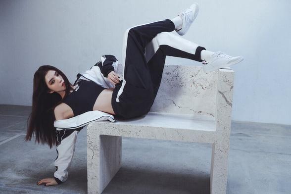 Han So-hee modelling Fila's F-Box Anniversary campaign, leaning back on stone bench.
