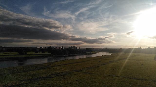 kurz vor Sonnenuntergang, Fluss, Wiesen, Wolken und Heißluftballons