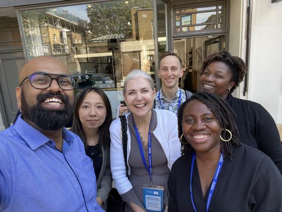 Group of people outside a cafe smiling in a selfie