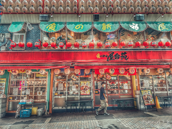 Casual restaurant with bright red sign at the entrance that has lots of lanterns hanging.