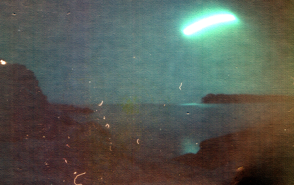 sonnenbogen über dem meer mit klippen im vorder- und hintergrund.