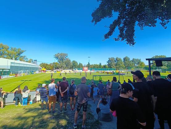 Aussicht von der Zuschauertribüne auf einen Fußballplatz, auf dem Hobbykicker den Band Fußball Cup bestreiten