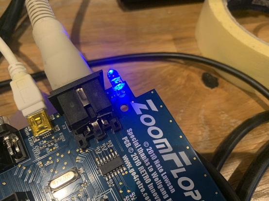 The ZoomFloppy USB to IEC interface with its blue LED shining brightly.