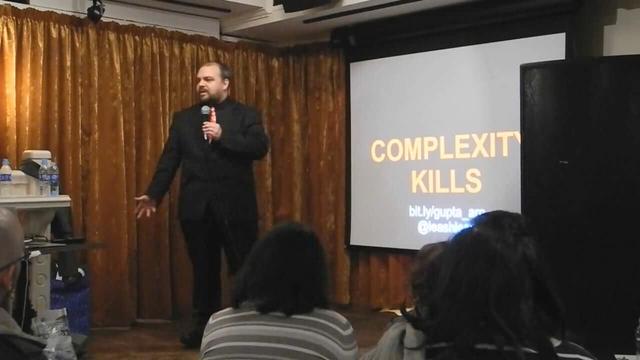 Vinay Gupta, disaster management planner, in front of the title slide of his presentation Complexity Kills, at The Event, Leila Johnston’s talk series on catastrophic risks.