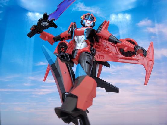A photo of Transformers Adventure Windblade, in robot mode, in front of a sky backdrop.