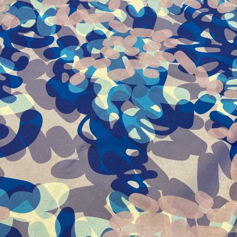 Close-up of abstract printed fabric design in grey-violet, dark blue, sky blue, white, and pale grey-pink. It is of overlapping transparent lozenge shapes with a somewhat leafy and flower petal nature. The design name is Ruska 3 version 4.
