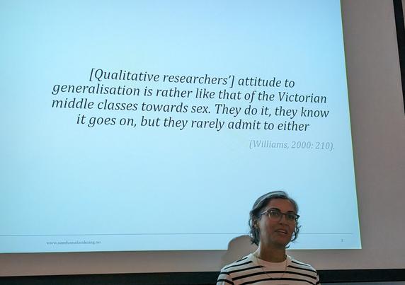 Marjan, standing in front of a slide with the following quote: "[Qualitative researchers'] attitude towards generalisation is rather like that of the Victorian middle classes towards sex. They do it, they know it goes on, but they rarely admit to either" (Williams, 2000: 210)