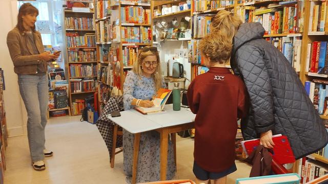Author Cressida Cowell signing for a long line of happy schoolchildren in the Edinburgh Bookshop, after giving a presentation in the local Bruntsfield Primary School