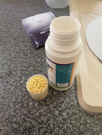 Galen microtabs pills in a cup, and the bottle with the lid open. The PKU Sphere 20 is in the background. And yes, this was taken at my new house, thank you for noticing!