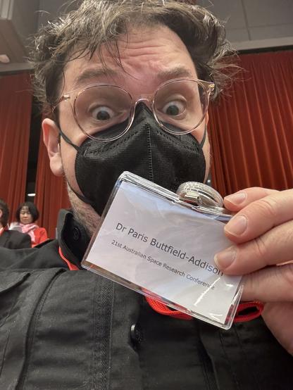 Me, a white guy, holding a badge with my name on it at the 21st Australian Space Research Conference