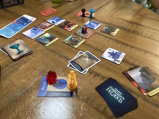 Board game pieces on a table, showing very little remaining of the island in the game