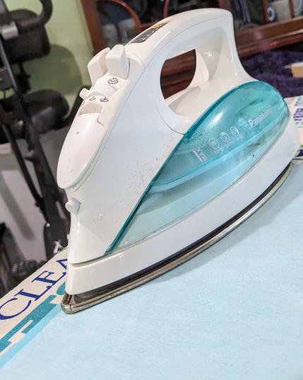 an iron steaming fabric on top of an ironing board