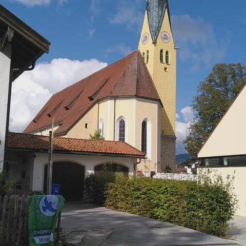 Eine C4F-Fahne hängt am Zaun vor einer Kirche.