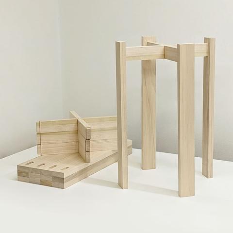 The legs of a poplar stool stand beside the pieces for 3 more stools.