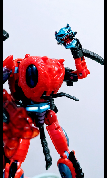 A Transformers action figure from the Legacy Evolution toy line, representing the character Inferno from Beast Wars, holding his own head in one hand.
