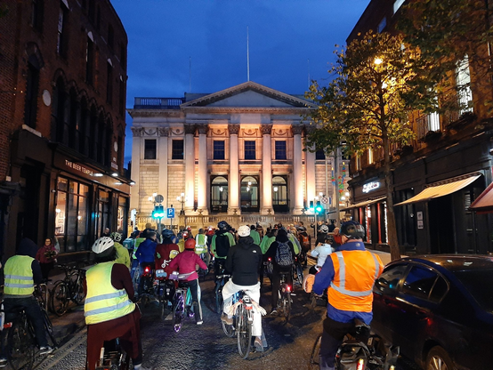 View looking up Parliament St. Dublin of a group cycling towards the city hall.