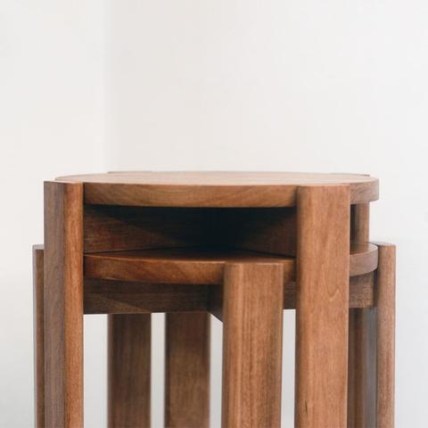 A close up on the top of two poplar stools stacked on top of each other. The legs allow the stools to nest together taking up less space.