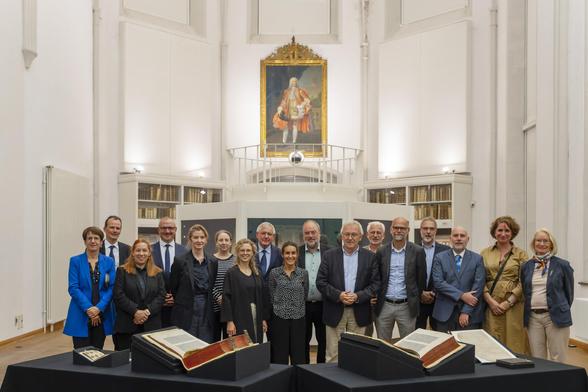 Gruppenbild des deutschen Nominierungskomitees für das UNESCO-Programm „Memory of the World“ in der Paulinerkirche der SUB Göttingen, im Vordergrund die Göttinger Gutenberg-Bibel.
