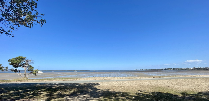 Looking SE from Victoria Point park over Redland Bay. Tide out showing mud flats and water in middle distance, islands in the background with blue skies, close your eyes and feel the cooling breeze…ahhhhh