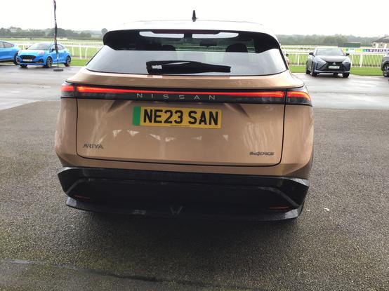 Copper metallic Nissan Ariya with black roof, rear view