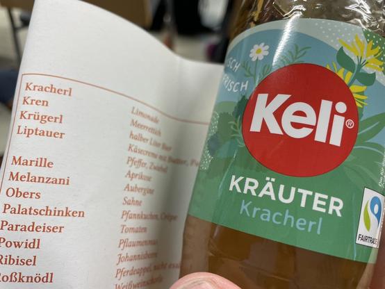 Im Vordergrund eine Flasche mit der Beschriftung âKrĂ€uterkracherlâ. Im Hintergrund der Konferenzplan mit der ErlĂ€uterung âKracherl â Limonadeâ