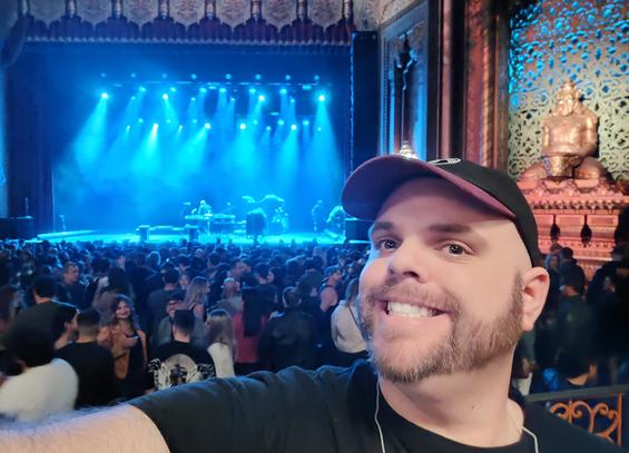 Selfie of myself in the Fox Theater in Oakland as stage workers reset the stage before an audience.