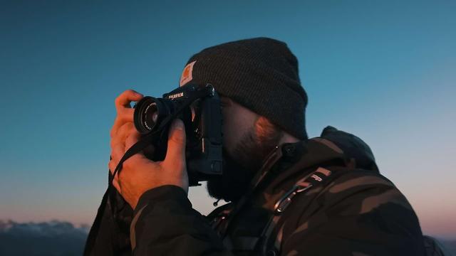 Photographer shooting a sunset in the mountains