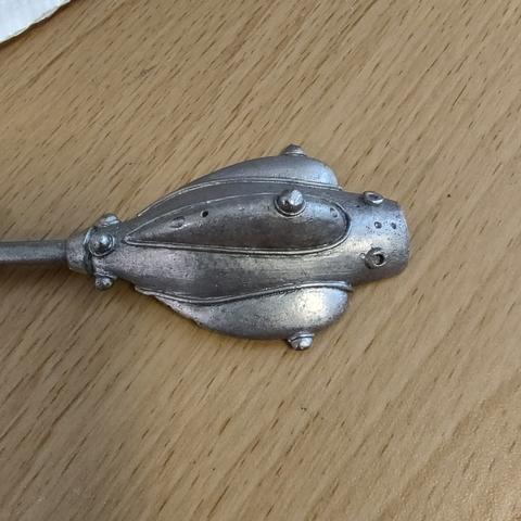 A piece of a lead spaceship miniature, without the corrosion seen in the first picture.