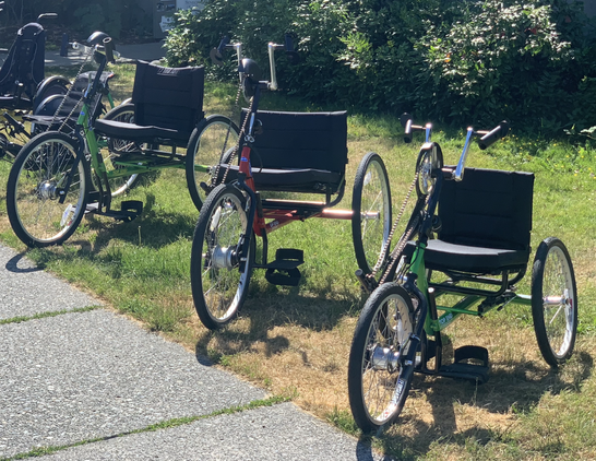 Several handcycles with an upright seating position.
