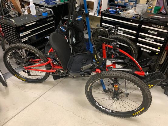 A red, reclined mountain bike handcycle, with suspension!