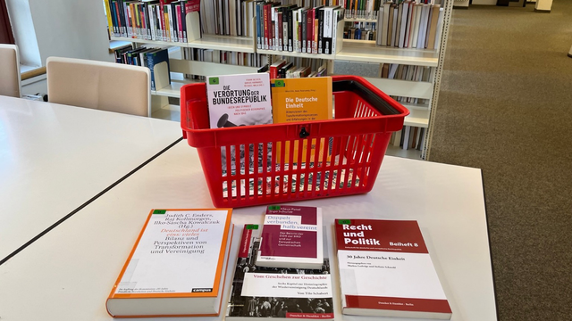 Bücher auf dem Tisch und in einem Korb. Bücher zum Thema Tag der Deutschen Einheit.