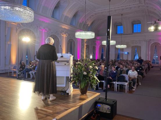 Claudia Roth hält im vollbesetzten Weißen Saal ihr Grußwort.