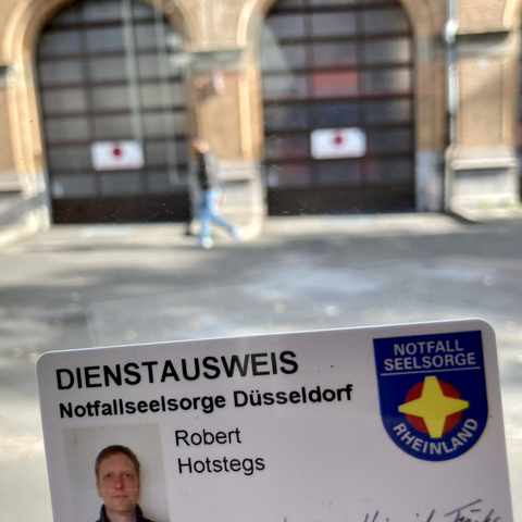 Dienstausweis der Notfallseelsorge Düsseldorf vor der Feuerwache 1 Hüttenstraße.