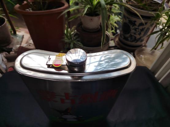 Top of the flask before opening, showing the traditional hip-flask style cover and the seal.