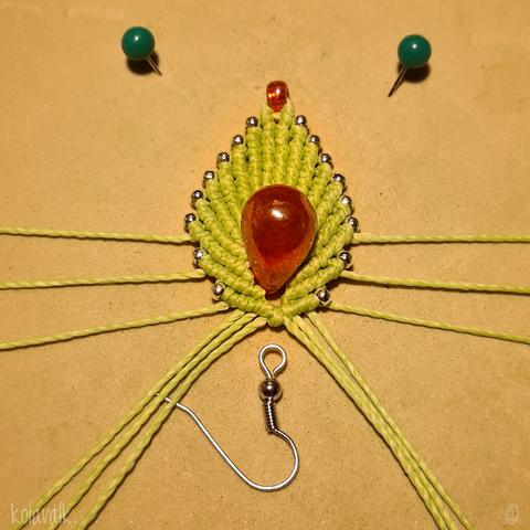 Détail de la première boucle d'oreille presque terminée, à l'envers, il ne reste plus que l'attache de métal argenté à rattacher.