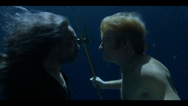 Screenshot from the show Our Flag Means Death. Underwater, Ed gazes at a mermaid - Stede, the other male lead of the show. Ed leans in.