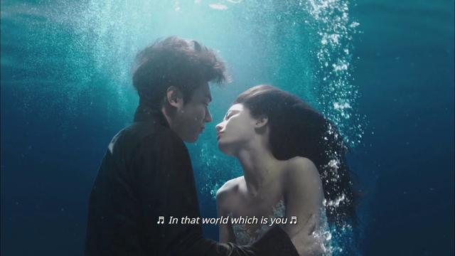 Screenshot from the kdrama Our Flag Means Death. Underwater, Joon-jae gazes at a mermaid - Shim Cheong, the female lead. Shim Cheong leans in.