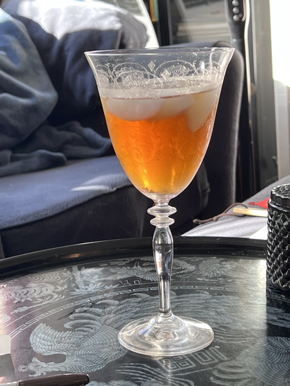 Tall etched glass goblet with golden iced tea.