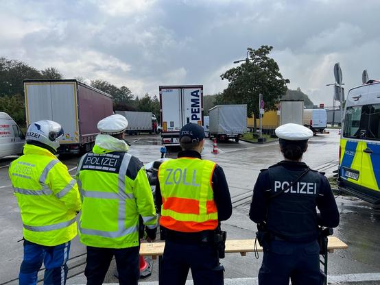 Einsatzkräfte von Bundespolizei, Landespolizei und Zoll stehen auf einem Parkplatz (Symbolbild).