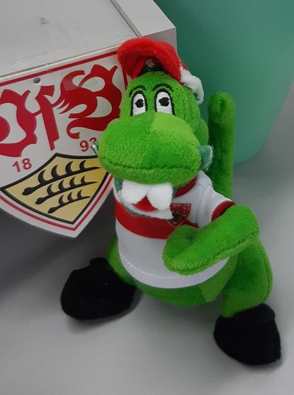 A photo of a stuffed animal, a crocodile. It is the mascot of the soccer club Stuttgart.