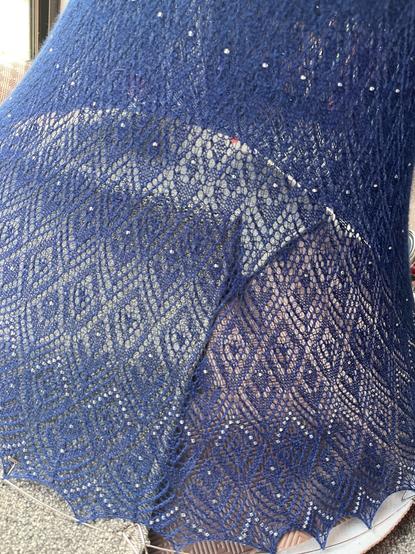 Lace detail of a knitted skirt being blocked. The skirt has silver beads.