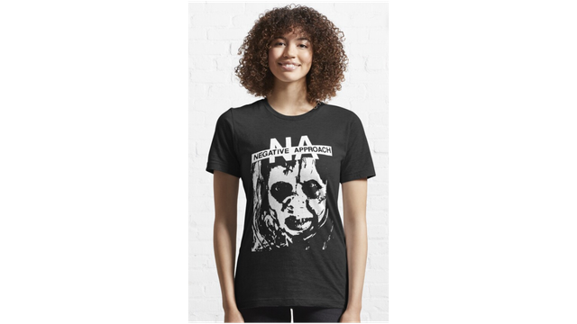 Young cheerful woman wearing t-shirt of punk band Negative Approach. On the t-shirt is a gloomy disturbing face of a woman.
